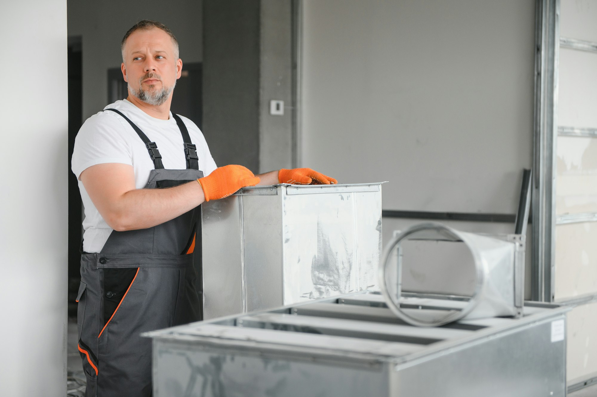 Man repairman. Master near ventilation pipes. Installation of ventilation for buildings.